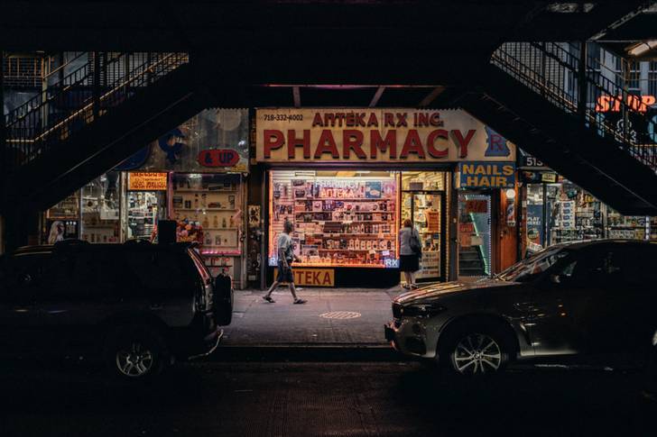 a bodega at night under an elevated train track
